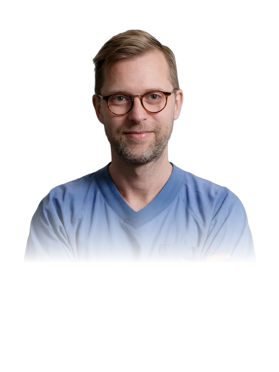 Prof. Gustav Stålhammar in blue scrubs, arms crossed